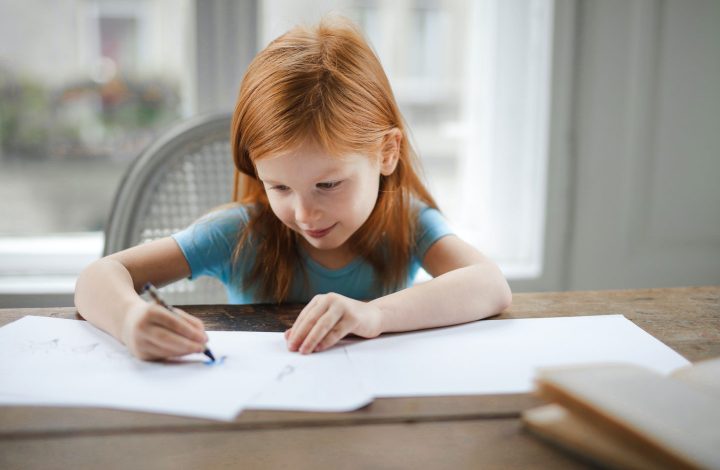 A young girl writes in a book